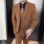 The groom is a dashingly handsome man in a slim-fit, peak lapel suit jacket, a business casual suit set in a British style.